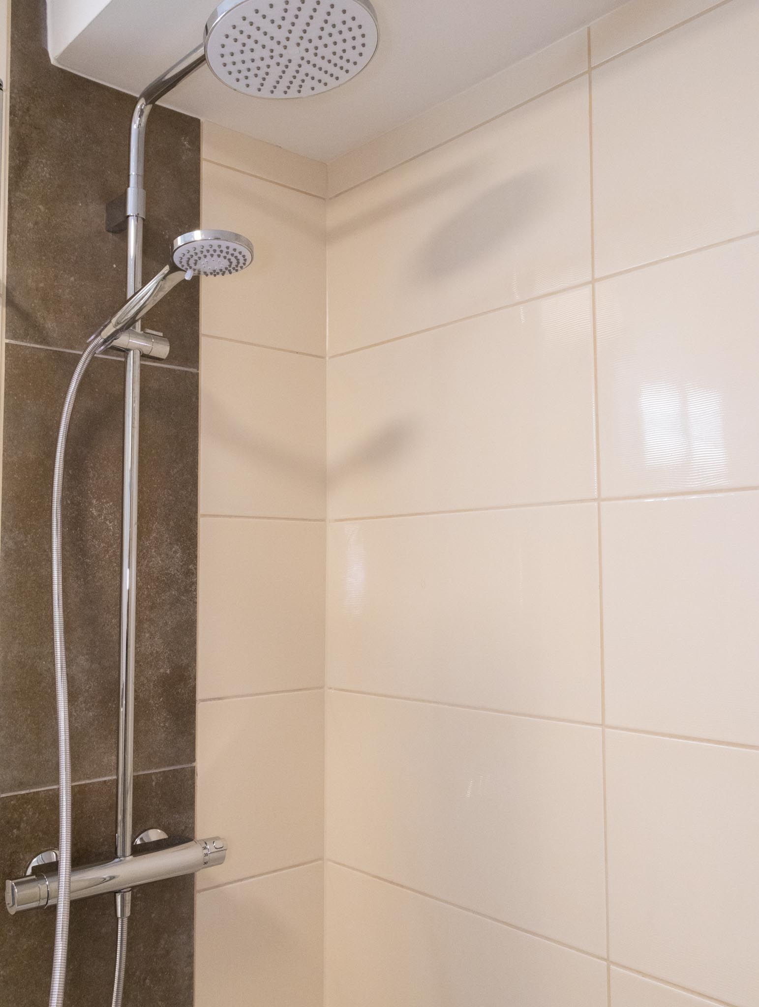 Badezimmer mit Duschbrause im FairSchlafen Boutique Hotel