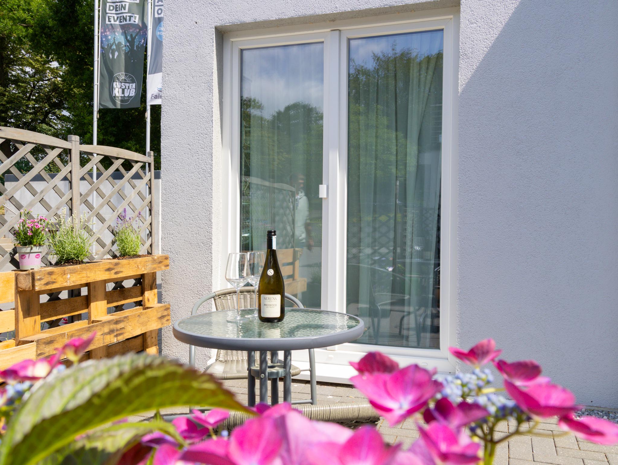 Terrasse mit Wein und Blumen im FairSchlafen Boutique Hotel